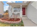 Inviting covered front porch featuring classic white pillars and a vibrant red door at 1189 Fall River Cir, Longmont, CO 80504