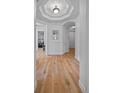 Open hallway with wood floors, white walls, archways, and decorative mirror at 45 N Ogden St # 309, Denver, CO 80218