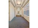 Long hallway featuring coffered ceilings, chandelier lighting, and patterned carpet at 45 N Ogden St # 309, Denver, CO 80218