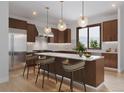 Modern kitchen with wooden cabinets, stainless steel appliances, a marble counter, and island seating at 528 N Fuller Placer, Breckenridge, CO 80424