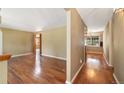 Bright living room with hardwood floors and open doorway to dining area with natural light at 10868 W 70Th Ave, Arvada, CO 80004