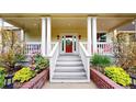 Charming front porch with white columns and steps leading to a vibrant red front door at 2334 Yosemite St, Denver, CO 80238