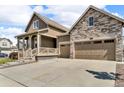 Well-maintained two-story home with a combination of siding and stone facade, two-car garage, and a manicured lawn at 5045 Preserve Pl, Firestone, CO 80504