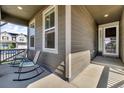 Inviting covered front porch with comfortable rocking chairs, offering a relaxing outdoor space at 5045 Preserve Pl, Firestone, CO 80504