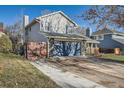 Two-story house with gray siding, stone accents, and a blue garage door at 11759 E Asbury Ave, Aurora, CO 80014