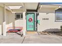 House entrance with a teal door and red bench at 1488 S Fairfax St, Denver, CO 80222