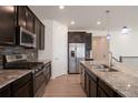 Modern kitchen featuring stainless steel appliances, dark cabinetry and an island with pendant lighting at 24314 E Ford Ave, Aurora, CO 80018
