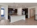 Well-lit kitchen with stainless steel appliances, dark cabinetry and an island with pendant lighting at 24314 E Ford Ave, Aurora, CO 80018