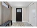 Neutral entryway with black door and wood feature wall at 6443 Reed Ct, Arvada, CO 80003