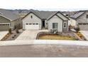 Charming home featuring a well-maintained lawn, driveway, and a cozy front porch, complete with seating and decorative plants at 8985 Chalk Creek Pl, Littleton, CO 80125