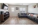 Comfortable living room features wood floors, large sectional couch, and plenty of natural light at 18726 E Yale Cir # D, Aurora, CO 80013