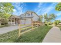 Inviting two-story home with a well-manicured lawn, a charming porch, and a two-car garage at 5457 S Valdai St, Aurora, CO 80015
