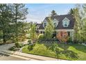 Beautifully landscaped front yard with a charming brick home and mature trees at 7770 S Ivy Way, Centennial, CO 80112