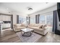 Bright living room with neutral color palette, large windows, and hardwood floors at 10207 Xanadu St, Commerce City, CO 80022
