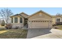 Charming home featuring a two-car garage, stone accents, manicured lawn, and inviting front entrance at 10340 Winona Ct, Westminster, CO 80031