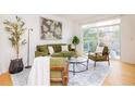 Bright living space with a sofa, chairs, and sliding glass door to a balcony at 1747 N Washington St # C303, Denver, CO 80203