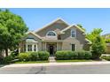 Charming home showcasing lush landscaping, gray siding, gabled roof, and a well-manicured lawn at 4545 S Monaco St # 114, Denver, CO 80237