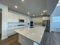 Bright, open kitchen featuring stainless steel appliances, a large island with quartz countertops, and custom cabinets at 651 Sunrise St, Erie, CO 80516