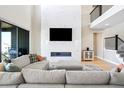 Stylish living room showcasing high ceilings, modern fireplace, large TV, and comfortable sectional sofa at 6955 Sunstrand Ct, Castle Pines, CO 80108