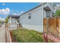 Home exterior featuring a porch, a green lawn, and a well-maintained fence for added privacy at 8400 Adams Way, Denver, CO 80229