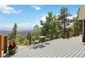 Enjoy mountain views from this outdoor deck space with table, chairs, and potted plants at 11760 Baca Rd, Conifer, CO 80433