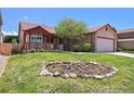 Inviting home with a flower garden in the front yard and a cozy porch with red trim accents at 5554 S Ward Way, Littleton, CO 80127