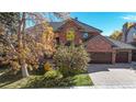 Charming red brick home with well-maintained landscaping and a two-car garage at 10346 E Crestridge Ln, Englewood, CO 80111