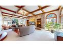 Spacious living room featuring a brick accent wall, wood-beamed ceiling, and lots of natural light at 10346 E Crestridge Ln, Englewood, CO 80111