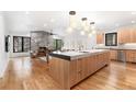 Spacious open-concept kitchen featuring an expansive island, fireplace, and modern lighting at 1675 S Steele St, Denver, CO 80210