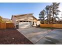 Well-maintained home featuring a spacious concrete driveway leading to a two-car garage, complemented by stylish stone accents at 93 Greeley Blvd, Palmer Lake, CO 80133