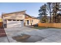 Inviting home with a modern design, showcasing a spacious driveway, manicured lawn, and a welcoming front entrance at 93 Greeley Blvd, Palmer Lake, CO 80133