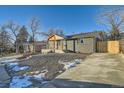 Modern home with gray brick exterior, wood accents, and landscaped yard at 71 W Fremont Ave, Littleton, CO 80120