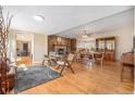 Spacious living room with hardwood floors and stone fireplace, seamlessly flowing into the dining area at 16805 W 16Th Pl, Golden, CO 80401