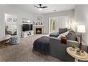 Cozy living room with fireplace, ceiling fan, and sliding doors to balcony at 23346 E 5Th Pl # 101, Aurora, CO 80018