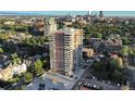 High-rise condominium building surrounded by mature trees and lush landscaping, offering stunning city and mountain views at 130 N Pearl St # 1606, Denver, CO 80203