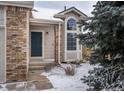 Home entrance with a dark blue door, brick accents, and a large window for ample natural light at 10510 Berthoud Way, Parker, CO 80134