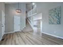 Inviting entryway showcasing beautiful wood floors, an open staircase, and modern lighting fixtures at 10510 Berthoud Way, Parker, CO 80134