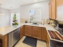 Bright kitchen featuring wood cabinets, a large window, stainless steel appliances, and an eat in counter at 12912 Grant Cir # A, Thornton, CO 80241