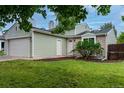 Home featuring a two-car garage, side door, and manicured lawn at 2777 S Sedalia St, Aurora, CO 80013