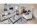 Bright living room features modern furniture, light hardwood floors, and an open view to the dining area at 6768 Vivian St, Arvada, CO 80004