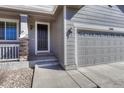 Close-up of the front door and two car garage highlighting the entry and architectural details at 7686 Grady Cir, Castle Rock, CO 80108