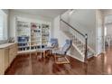 Cozy living room with built-in bookshelves, hardwood floors, and staircase at 7686 Grady Cir, Castle Rock, CO 80108