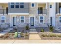 A modern townhome entrance features a stone facade, minimalist landscaping, and a welcoming, contemporary design at 20578 E 63Rd Ave, Aurora, CO 80019
