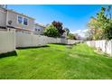 Large, grassy backyard enclosed by a pristine white fence offers privacy and space for recreation at 9713 W Chatfield Ave # F, Littleton, CO 80128