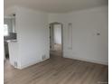 Bright living room with fresh paint, hardwood floors, an arched doorway, and stylish trim at 3243 Albion St, Denver, CO 80207