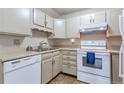 Bright kitchen with white cabinets, and modern appliances including a dishwasher and a range at 13606 E Bates Ave # 102, Aurora, CO 80014