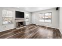 Inviting living room with hardwood floors, brick fireplace, and a large window that fills the space with natural light at 1712 S Kline Way, Lakewood, CO 80232