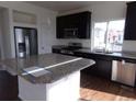 Modern kitchen with stainless steel appliances, a kitchen island, and granite countertops at 4551 N Quemoy St, Aurora, CO 80019