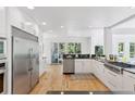 Bright kitchen features stainless appliances, hardwood floors, white cabinetry and plenty of sunlight at 6128 Songbird Cir, Boulder, CO 80303