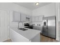 Bright kitchen with white cabinets, quartz countertops, stainless steel appliances, and modern fixtures at 5112 Duluth Ct, Denver, CO 80239